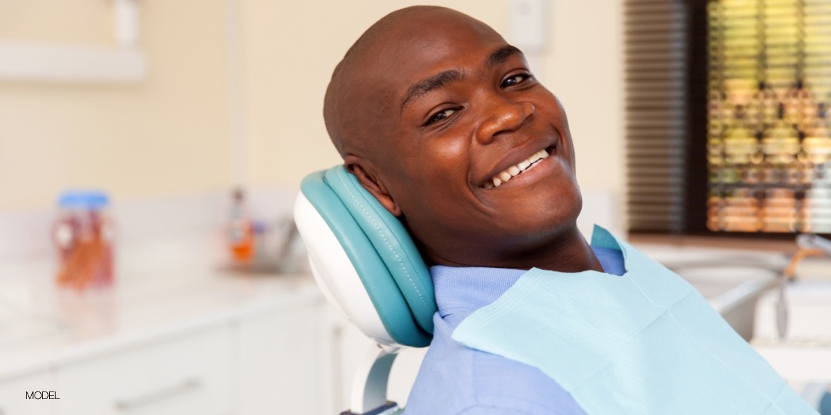 African American man smiling and sitting in dental chair