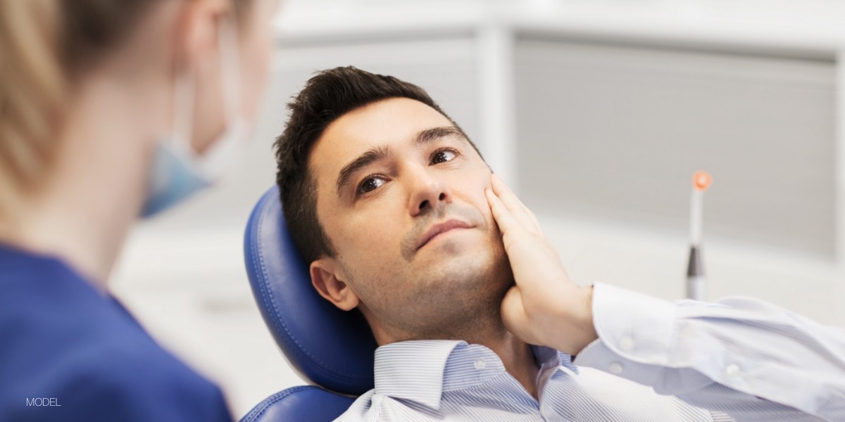 Man in Dental Chair Looking Concerned about Tooth Sensitivity